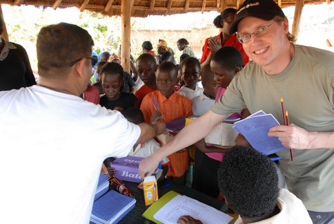 Mike and Umesh handing out pencils and books